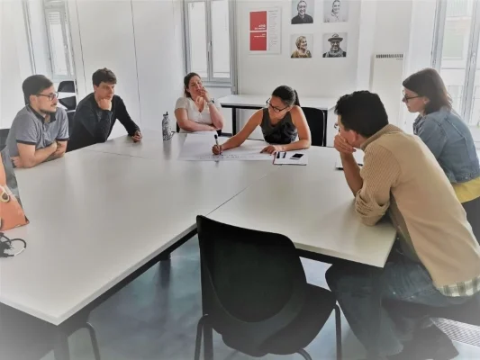 Impressionen aus der Schulung "Weiterbildungen inklusiv gestalten" Schulungsteilnehmende diskutieren und beschriften Flipchart