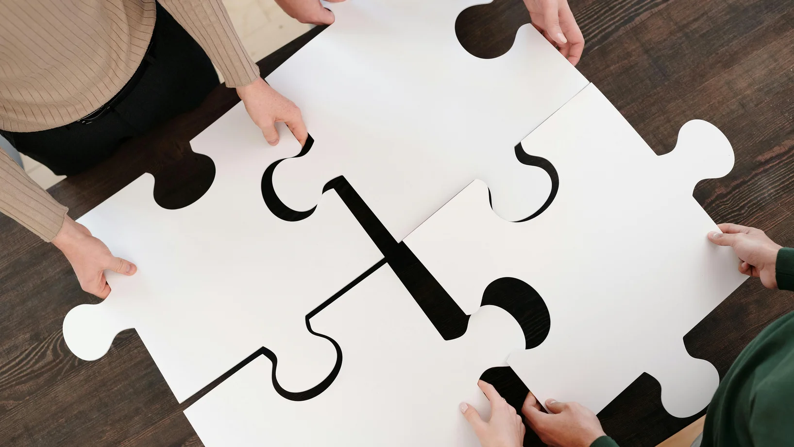 Close up photo of people holding puzzle pieces